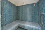 Experience ultimate relaxation in this beautifully tiled steam room, featuring a built-in bench for comfort.