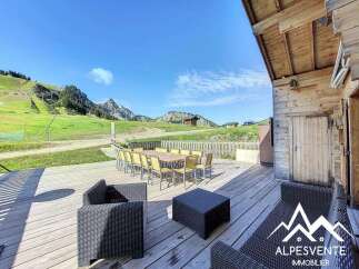 Enjoy breathtaking mountain views from this charming wooden chalet's expansive deck.