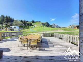 Enjoy breathtaking mountain views from this stunning property's expansive wooden deck, perfect for al fresco dining or relaxing.
