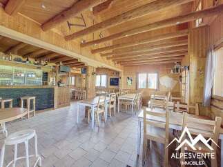 Experience the rustic charm of this mountain restaurant, featuring a warm wooden interior with exposed beams and a cozy bar area.