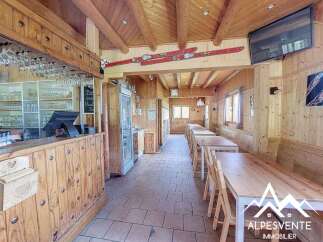 Step into this charming mountain restaurant, featuring a rustic wooden interior and a well-equipped bar area.