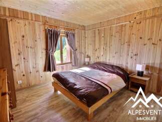 Experience rustic charm in this cozy bedroom, featuring warm wooden walls and flooring that create a serene mountain retreat atmosphere.