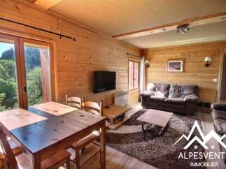 Experience cozy living in this charming wooden chalet, featuring a spacious living area with comfortable seating and a large dining table perfect for family gatherings.