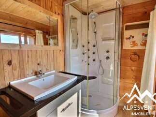 Experience modern comfort in this charming bathroom, featuring a sleek white sink and a spacious, multi-jet shower cabin.