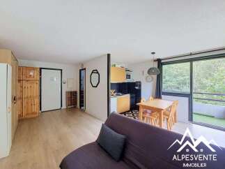 Discover this charming apartment featuring a bright living area with a dining table and a modern kitchen.