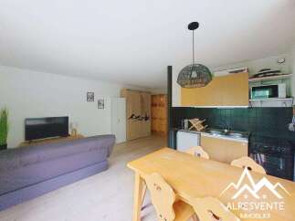 This charming studio apartment offers a comfortable living space with a cozy sofa and a television, perfect for relaxing after a day of exploring.