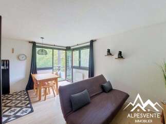 Discover this charming living space featuring a comfortable sofa bed and a dining area perfect for meals.