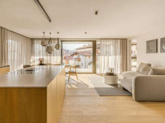 Experience modern living in this stunning open-plan apartment featuring a sleek kitchen island with integrated stovetop and a spacious living area.