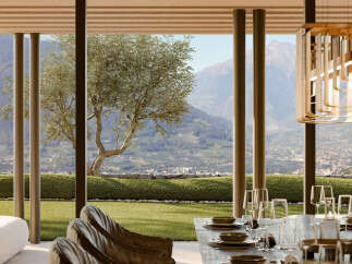 Experience breathtaking mountain views from this exquisite dining area, featuring a beautifully set table ready for guests.