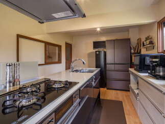 Discover this modern kitchen featuring a sleek gas stovetop and a deep stainless steel sink, perfect for culinary enthusiasts.