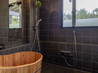 Experience ultimate relaxation in this luxurious bathroom featuring a traditional wooden soaking tub, perfect for unwinding after a long day.