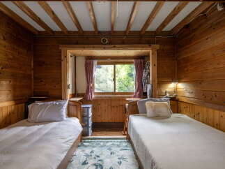 Experience rustic charm in this cozy cabin bedroom, featuring two comfortable twin beds perfect for guests or family.