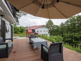 Enjoy outdoor living on this spacious deck, perfect for entertaining or relaxing amidst lush greenery.