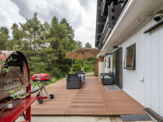 Enjoy outdoor living on this spacious wooden deck, perfect for entertaining or relaxing amidst nature.