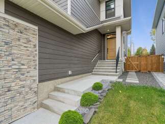 Discover modern living with this stunning home featuring a striking stone accent on the exterior, complemented by sleek dark siding.