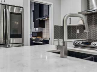 Experience modern living in this stunning kitchen, featuring sleek stainless steel appliances including a Samsung refrigerator and a high-end range.
