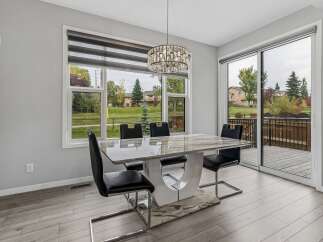 Experience elegant dining in this modern space, featuring a stunning marble-top dining table with sleek black chairs.