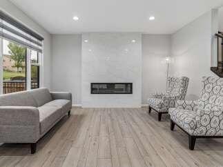Experience modern living in this spacious living room, featuring a sleek gas fireplace with a stunning marble surround.
