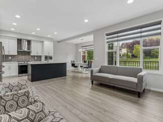 Experience modern living in this open-concept space featuring a sleek kitchen with a large island and a stylish dining area.