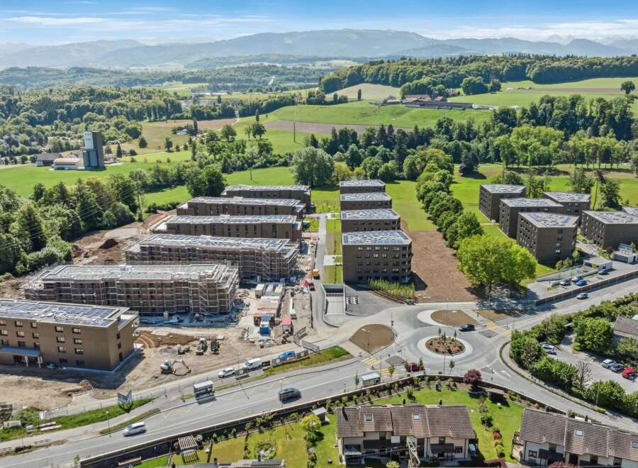 Discover modern living in this new construction development featuring multiple apartment buildings with contemporary architecture and solar panels on the roofs.