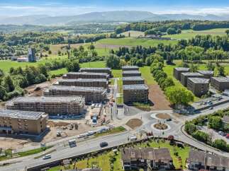 Discover modern living in this new construction development featuring multiple apartment buildings with contemporary architecture and solar panels on the roofs.