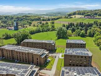 Discover modern living in this expansive residential complex, featuring multiple apartment buildings equipped with state-of-the-art solar panel systems on their rooftops.