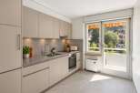 Discover this modern kitchen featuring sleek, taupe cabinetry and a sophisticated stone backsplash.