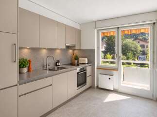 Discover this modern kitchen featuring sleek, taupe cabinetry and a sophisticated stone backsplash.