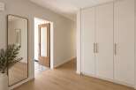 Step into a beautifully designed hallway featuring a full-length mirror with a brass frame, reflecting the natural light and adding a touch of elegance.