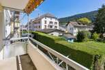 Enjoy the scenic views from this balcony, overlooking a lush green garden and charming residential buildings.