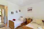 This charming bedroom features two twin beds with wooden frames, perfect for accommodating guests or family.