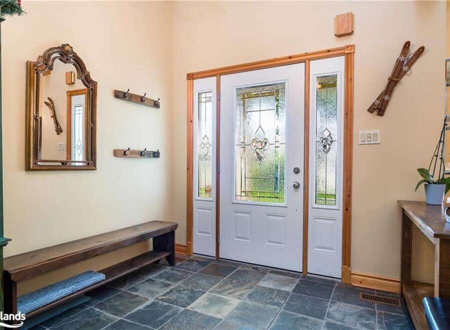 Step into a welcoming entryway featuring a rustic wooden bench and a decorative mirror, perfect for a cozy mountain retreat.