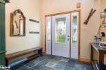Step into a welcoming entryway featuring a rustic wooden bench and a decorative mirror, perfect for a cozy mountain retreat.