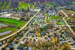 Experience luxury living in this stunning aerial view of a picturesque neighborhood nestled beside a golf course and ski hills.