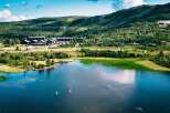 Experience the ultimate mountain getaway with this stunning aerial view of a lakeside resort.