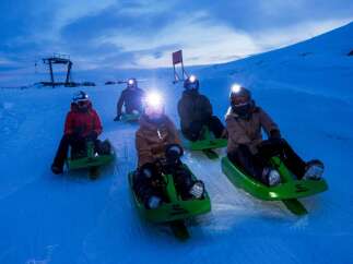 Experience the thrill of night sledding on this picturesque snowy slope.