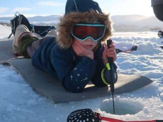 Experience the thrill of ice fishing in this picturesque winter wonderland.