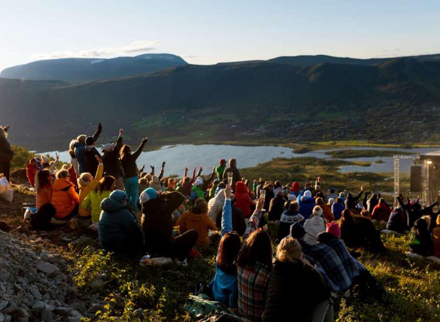 Experience an unforgettable outdoor concert set against a breathtaking mountain and lake backdrop.