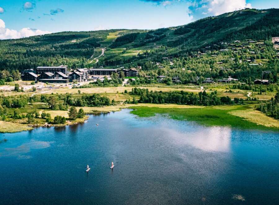 Experience the ultimate mountain getaway with this stunning aerial view of a lakeside resort.