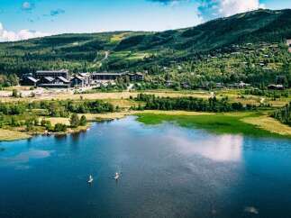 Experience the ultimate mountain getaway with this stunning aerial view of a lakeside resort.