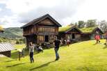 Experience the charm of traditional Norwegian architecture with these historic log cabins, featuring unique grass-covered roofs that blend seamlessly with the natural landscape.