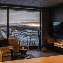 Experience breathtaking mountain views from this luxurious living room, complete with a cozy sectional sofa and a modern fireplace.