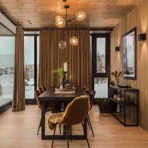 Experience luxurious mountain living in this stunning dining room, featuring a rustic wooden ceiling and walls that exude warmth and charm.
