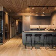 Experience modern living in this stunning kitchen and dining area, featuring sleek grey cabinetry and a spacious island with bar stools.