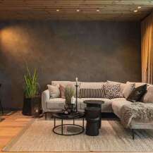 Experience luxurious mountain living in this stunning living room, featuring a plush sectional sofa adorned with decorative pillows and a cozy sheepskin throw.