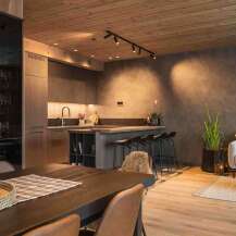 Experience modern mountain living in this beautifully appointed open-concept space, featuring a sleek, contemporary kitchen with a breakfast bar and ample storage.