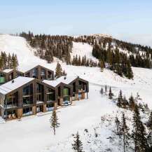 Experience luxury mountain living in these stunning modern chalets, nestled amidst a pristine snowy landscape.