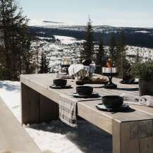 Experience the ultimate in outdoor living with this stunning dining setup, perfect for enjoying breathtaking mountain views.