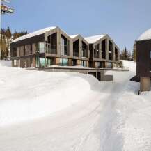 Experience luxury mountain living in this stunning modern chalet, perfectly situated on a snowy slope.