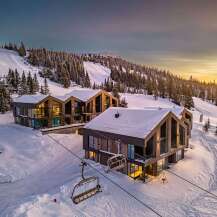 Experience luxury mountain living in these stunning modern chalets nestled on a snowy ski slope.